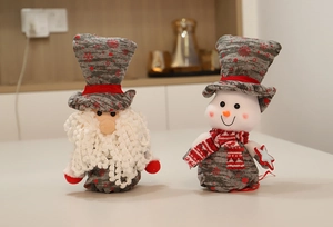 Detailed plush Santa and Snowman holiday gift bags with festive snowflake patterns