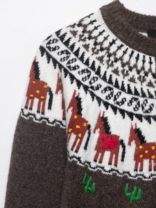 Detail of knit sweater with horse jacquard patterns and cactus embroidery on fabric