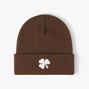 Dark brown knitted beanie with white clover embroidery for warmth in winter casual style