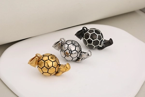 Detailed view of soccer pendants with wings in gold, silver, and black stainless steel