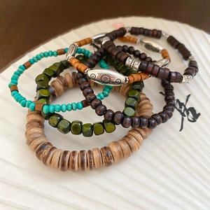 Detail of bohemian wooden beaded bracelet set with turquoise stones and sun charms