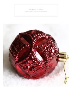 Close-up of red Christmas ornament with embossed patterns and gold hanging string