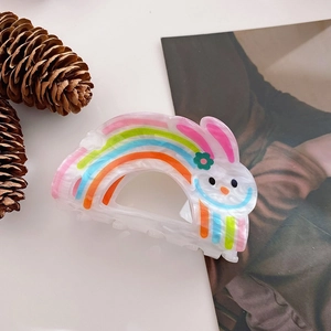 Close-up of cute rabbit acrylic hair claw clip with colorful rainbow stripes pattern