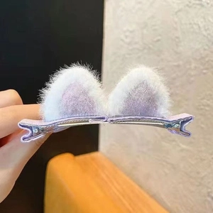 Detail view of plush purple and white cat ear hair clips with secure metal duckbill grip