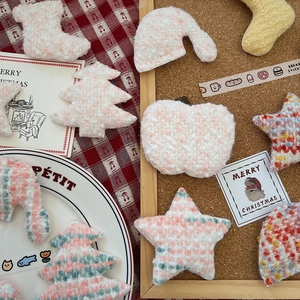 Detailed close-up of handmade knitted Christmas tree and star DIY craft accessories