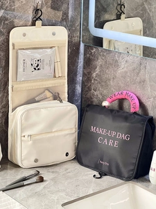 Large travel makeup bag with hanging hook and multi-layer storage shown on marble counter