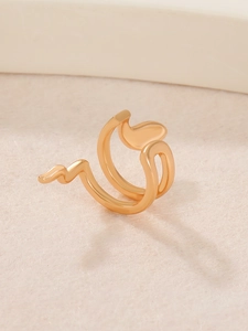 Vista macro di un anello a spirale dorato lucido su una base strutturata minimale