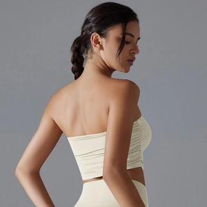 Detail view of the ruching on cream sports bra with moisture-wicking fabric