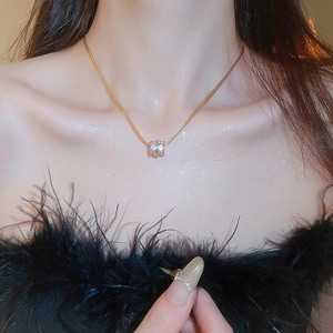 Golden multi-layer cylinder pendant necklace with sparkling cubic zirconia on a model