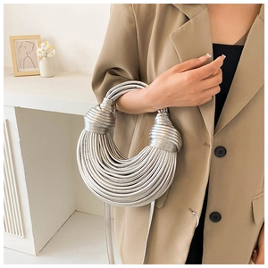 Detail of silver metallic woven handbag with knot design and unique ramen-style texture