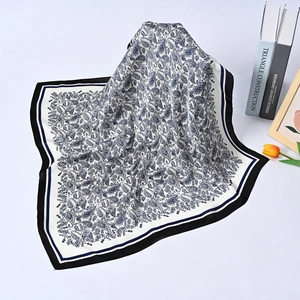 Blue and white paisley silk square scarf elegantly displayed with tulip and books