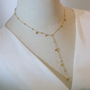 Y-shaped tassel necklace with polished gold beads on a 18K gold plated long chain