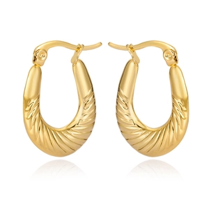 Close-up of golden textured hoop earrings with premium diagonal striped metal finish