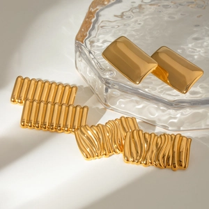 Three styles of gold geometric stainless steel earrings displayed on a white surface