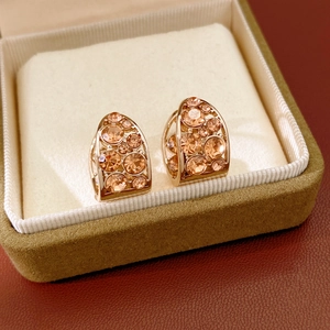 Vue détaillée des boucles d'oreilles en U en cristal champagne sur présentoir en velours