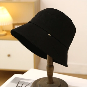 Classic black wide-brim cotton bucket hat with a minimalist gold metal logo accent
