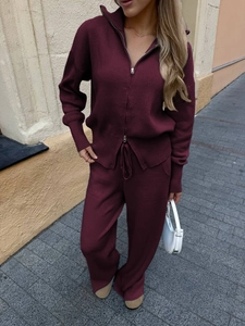 Close-up of elegant burgundy long-sleeve knitted zip-up sweater and matching pants set