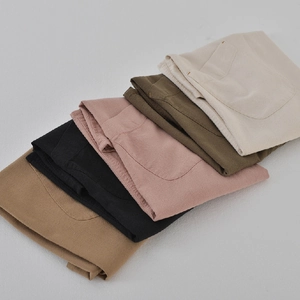Japanese style linen aprons in five solid colors folded neatly on a white background