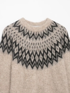 Close-up of winter alpaca blend knit sweater featuring geometric jacquard collar patterns