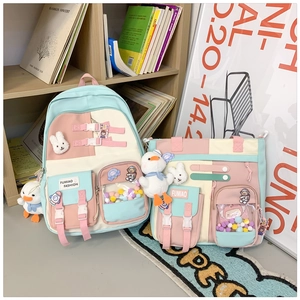 Detail of macaron-colored backpack set with plush pendants and clear PVC window