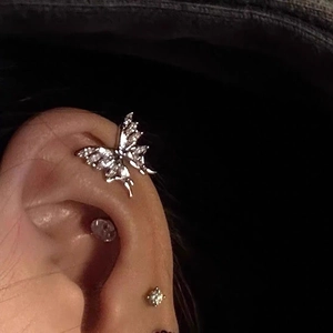 Detailed view of silver butterfly ear cuff with sparkling zircon on ear bone