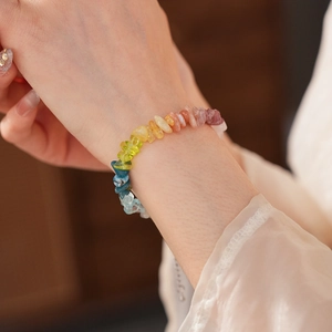 Close-up of a colorful rainbow natural stone beaded bracelet on a woman's wrist
