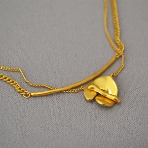 Macro shot of double-layered vintage brass necklace with gold-plated geometric pendant