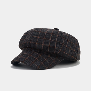 Detailed view of a retro British style plaid newsboy cap with orange grid pattern on gray