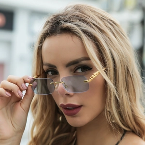 Detail of rimless square sunglasses with gold leopard metal temple and light blue lens