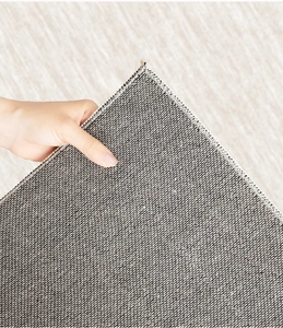 Close-up of the grey non-slip fabric backing and reinforced edges of the cream rug