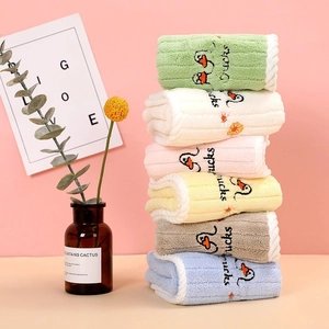 Detail of six colorful soft coral fleece towels with cute duck embroidery in a stack
