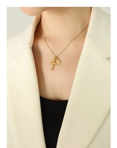 Gros plan d'un collier à double pendentif avec croix et médaille ovale sur un modèle