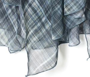 Detail showing blue and grey plaid fabric texture with asymmetrical hemline design