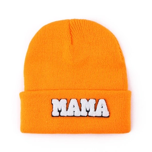 Close-up of bright orange knit beanie with white MAMA chenille embroidery texture