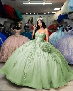 Detail of light green tulle prom dress featuring intricate sequins and floral embroidery