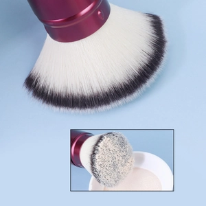 Detail showing soft dual-tone fiber bristles and red metallic handle of travel brush