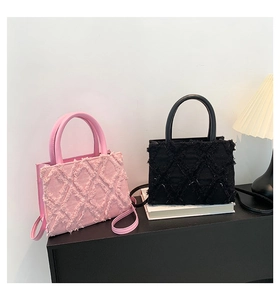 Detail of pink and black tote bags with diamond quilted fringe and textured canvas fabric