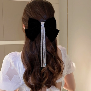 Detail of velvet bow hair clip with sparkling rhinestone tassels in a high pony tail