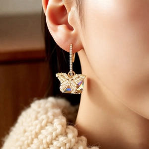Detail of luxury butterfly drop earring with sparkling zircon and champagne stone on model
