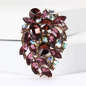 Close-up of purple crystal cluster brooch with gold base and intricate rhinestone detailing