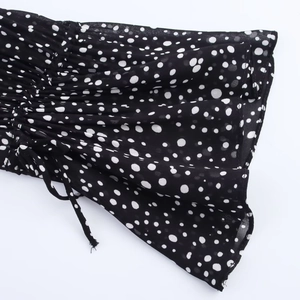 Detail shot of black and white polka dot chiffon fabric with drawstring and ruching