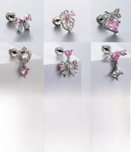 Detailed view of six silver stud earrings featuring pink zircon bows and heart shapes
