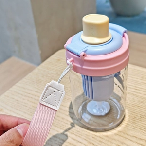 Detail view of pink and blue plastic water bottle lid with tea filter and carry strap