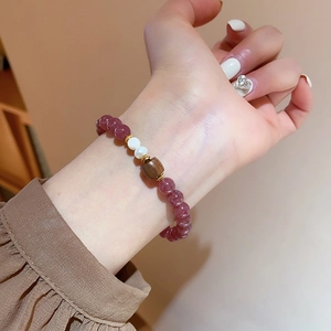 Detailaufnahme von Erdbeerquarz Armband mit Süßwasserperlen und Holzelementen am Handgelenk