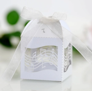 Détail d'une boîte cadeau blanche découpée avec notes de musique et ruban satiné