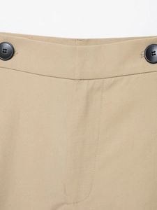 Detail of khaki twill trousers showing waist buttons and fabric texture on white background