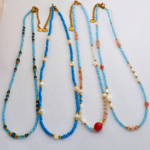 Detailed top view of four handmade beaded necklaces with natural stones and pearls