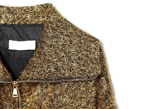 Detail shot of golden metallic bomber jacket fabric texture and premium metal zipper