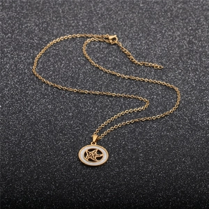Detail of a gold star necklace with white mother-of-pearl inlay on a black background