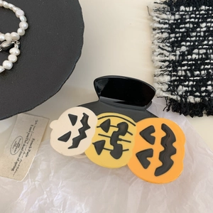 Close-up of three Halloween pumpkin hair claws in beige, yellow and orange acetate finish